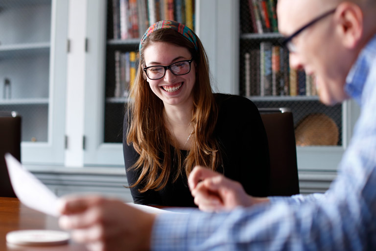 A student laughing with a faculty member