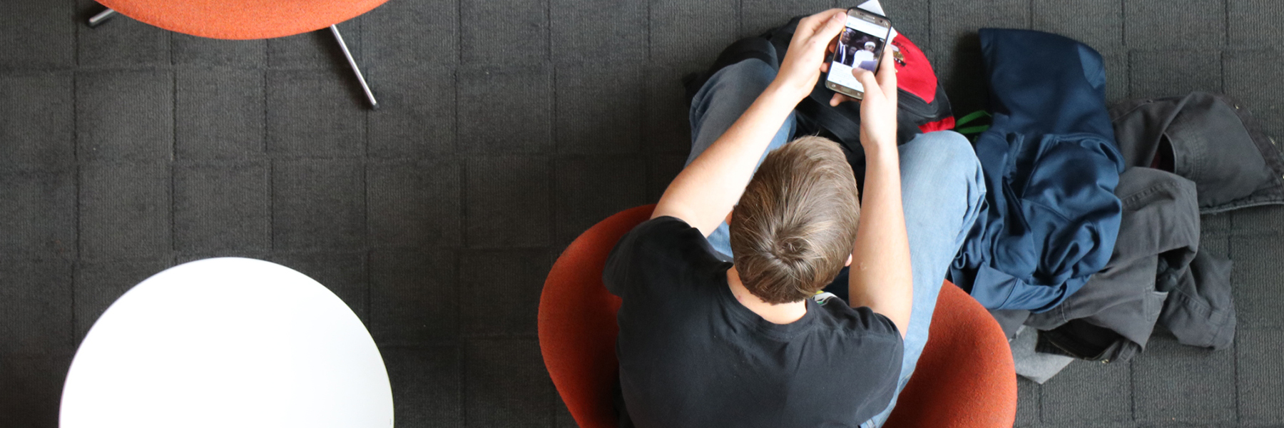 Over head of a student in the campus center on their phone.