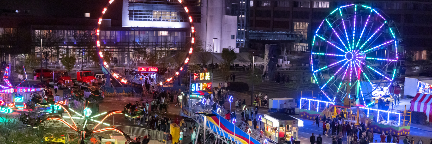 Jagapalooza rides at night time with bright lights on them.