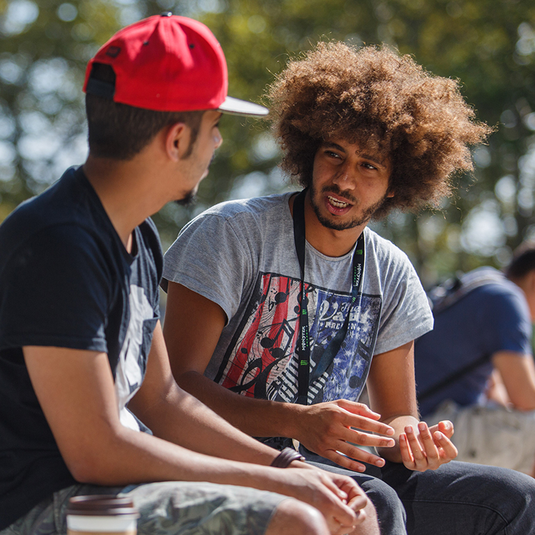 Two students talk outside of the campus center.
