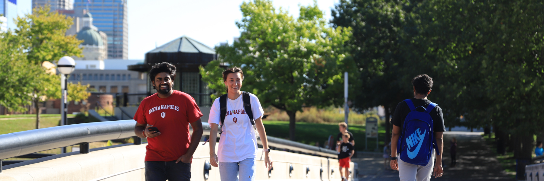 Students walking by the canal with the city in the background.